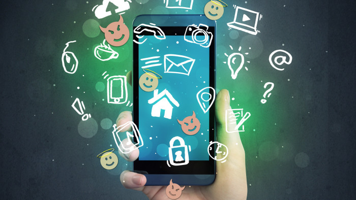 Hand hält Schmartphone. Um das Smartphone befinden sich unterschiedliche Icons