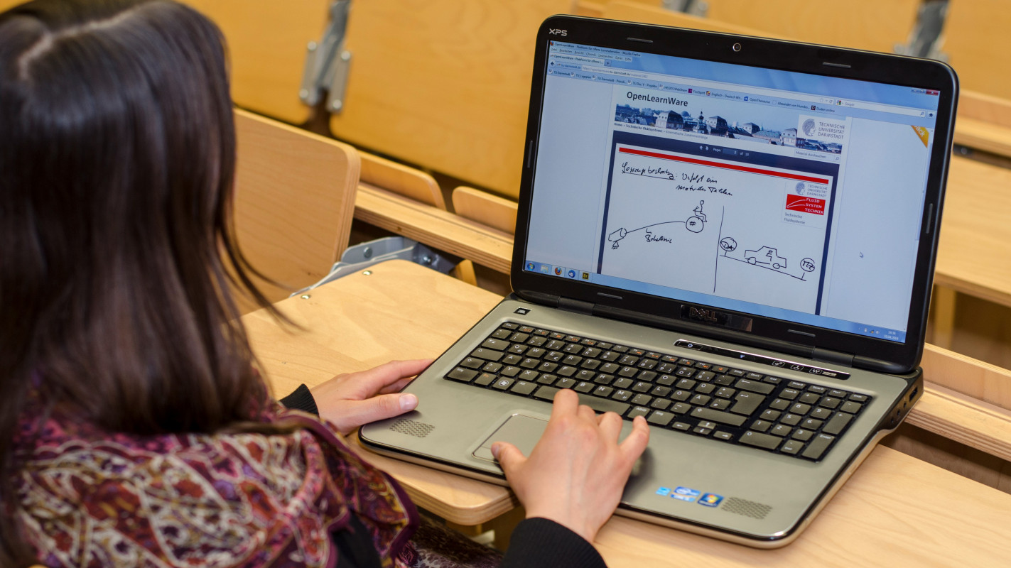 Eine Frau sitzt in einem Hörsaal und arbeitet an ihrem Laptop. Fotograf: Patrick Bal