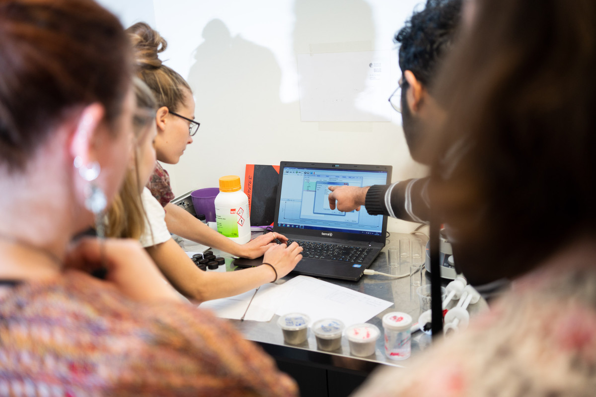Studierende gucken gemeinsam euf einen Laptop
