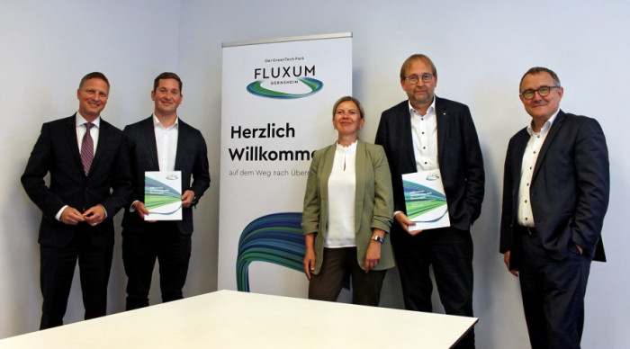 Fünf Personen stehen vor einem FLUXUM Rollup